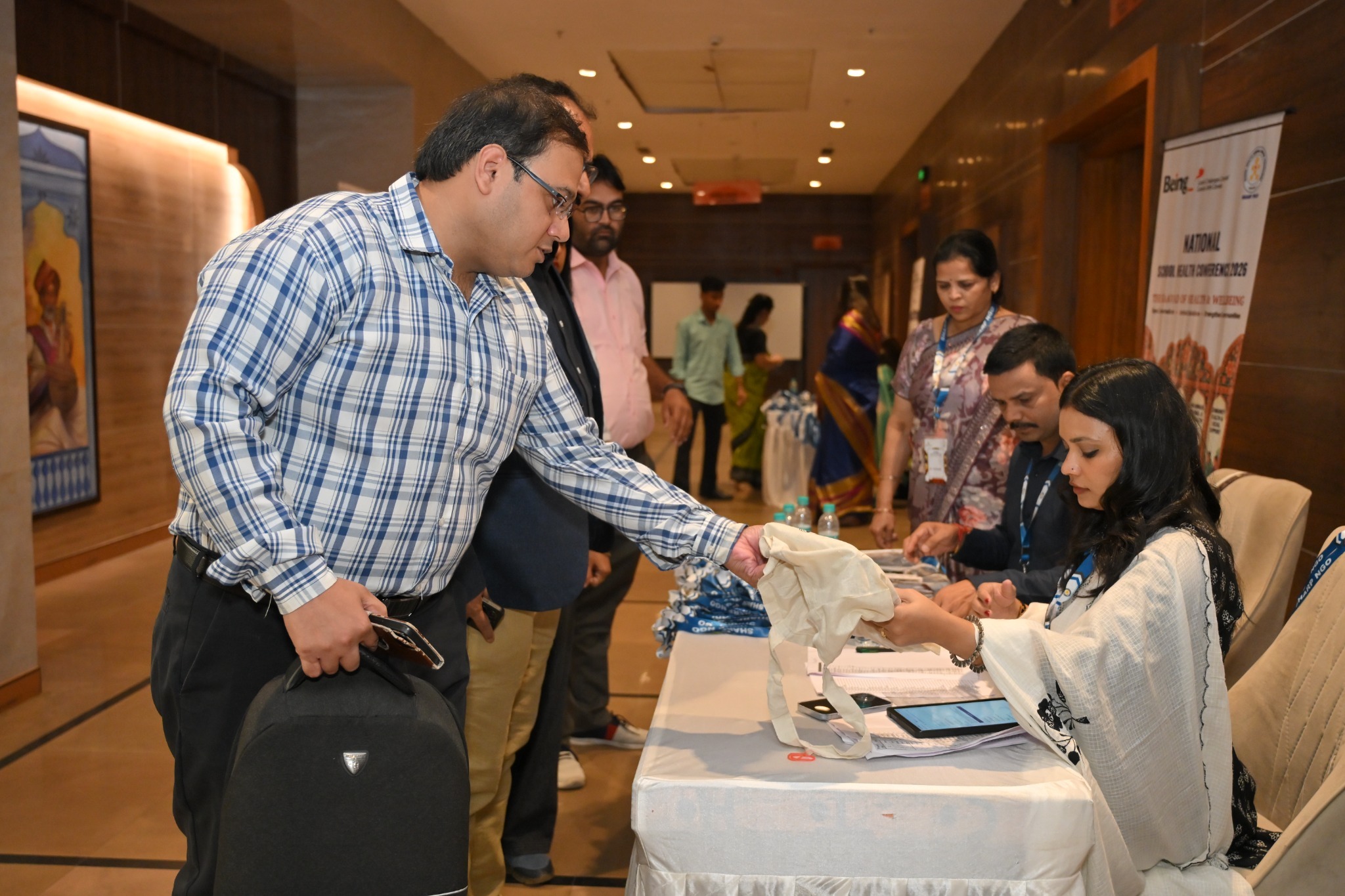 The organising team welcomes delegates and distributes conference materials at the registration desk.